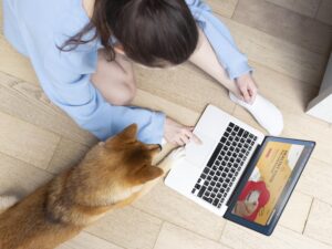 mujer-joven-trabajando-su-computadora-portatil-junto-su-perro-300x225